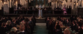 Movie still from “Harry Potter and the Order of the Phoenix” (2007), directed by David Yates – A group of people sitting in front of a priest; Wide shot, High angle