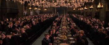 Movie still from “Harry Potter and the Order of the Phoenix” (2007), directed by David Yates – People sitting at a long dinner table with plates of food on it; Extreme Wide shot, High angle