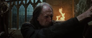 Movie still from “Harry Potter and the Order of the Phoenix” (2007), directed by David Yates – An old man sitting in front of a fire place; Close Up shot, Low angle
