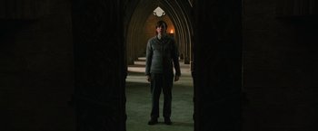 Movie still from “Harry Potter and the Order of the Phoenix” (2007), directed by David Yates – A man standing in the middle of an archway in a building; Wide shot, Low angle
