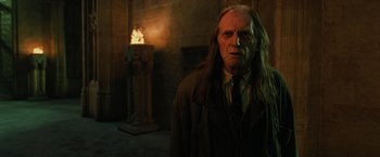 Movie still from “Harry Potter and the Order of the Phoenix” (2007), directed by David Yates – An old man with long white hair standing in front of a pillar; Medium shot, Low angle