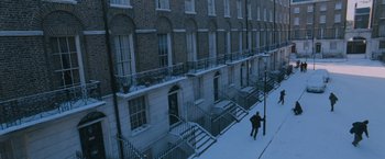 Movie still from “Harry Potter and the Order of the Phoenix” (2007), directed by David Yates – A man walking down a sidewalk in front of a row of buildings; Extreme Wide shot, High angle