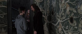 Movie still from “Harry Potter and the Order of the Phoenix” (2007), directed by David Yates – A man with long dark hair standing next to a wall; Medium shot, Over the shoulder angle
