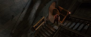 Movie still from “Harry Potter and the Order of the Phoenix” (2007), directed by David Yates – A man standing on the bottom of a set of stairs; Wide shot, Overhead angle