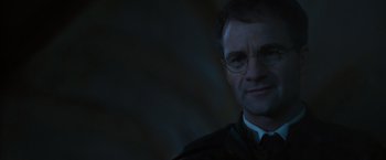 Movie still from “Harry Potter and the Order of the Phoenix” (2007), directed by David Yates – A person wearing a suit and glasses; Close Up shot, Low angle