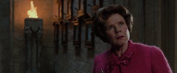 Movie still from “Harry Potter and the Order of the Phoenix” (2007), directed by David Yates – An older woman wearing a pink jacket looking off into the distance; Close Up shot, Low angle