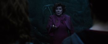 Movie still from “Harry Potter and the Order of the Phoenix” (2007), directed by David Yates – A woman in a purple dress is holding something in her hand; Medium shot, Over the shoulder angle