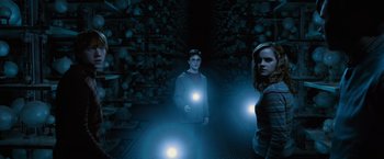 Movie still from “Harry Potter and the Order of the Phoenix” (2007), directed by David Yates – A man and a woman are in a dark room with lights on; Wide shot, Low angle