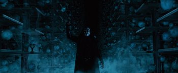 Movie still from “Harry Potter and the Order of the Phoenix” (2007), directed by David Yates – A man in a black mask is standing in a dark room; Medium shot, Low angle