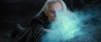 Movie still from “Harry Potter and the Order of the Phoenix” (2007), directed by David Yates – A man with long blonde hair is blowing smoke; Close Up shot, Low angle