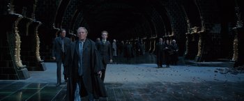 Movie still from “Harry Potter and the Order of the Phoenix” (2007), directed by David Yates – A group of people in suits and ties in a tunnel; Wide shot, Over the shoulder angle