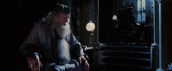 Movie still from “Harry Potter and the Order of the Phoenix” (2007), directed by David Yates – An old man sitting in a chair in a dark room; Medium shot, Low angle