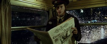 Movie still from “Harry Potter and the Prisoner of Azkaban” (2004), directed by Alfonso Cuarón – A man reading a newspaper while sitting in a vehicle; Close Up shot, Overhead angle