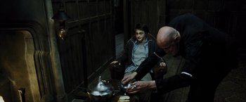 Movie still from “Harry Potter and the Prisoner of Azkaban” (2004), directed by Alfonso Cuarón – A man and a boy sitting at a table with a tea pot; Medium shot, Over the shoulder angle