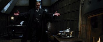 Movie still from “Harry Potter and the Prisoner of Azkaban” (2004), directed by Alfonso Cuarón – A man standing in front of a table with a tea pot on top of it; Medium shot, Low angle