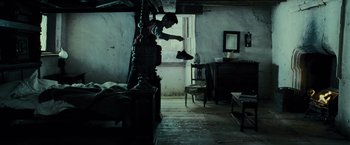 Movie still from “Harry Potter and the Prisoner of Azkaban” (2004), directed by Alfonso Cuarón – A man is putting something in a shoe; Wide shot, Low angle