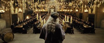 Movie still from “Harry Potter and the Prisoner of Azkaban” (2004), directed by Alfonso Cuarón – A man with long blonde hair standing in front of a group of people; Wide shot, High angle