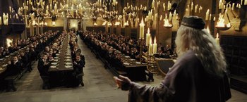 Movie still from “Harry Potter and the Prisoner of Azkaban” (2004), directed by Alfonso Cuarón – A group of people sitting in front of candles; Extreme Wide shot, High angle
