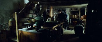 Movie still from “Harry Potter and the Prisoner of Azkaban” (2004), directed by Alfonso Cuarón – A man working in an old - fashioned workshop; Wide shot, High angle