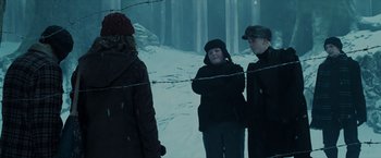Movie still from “Harry Potter and the Prisoner of Azkaban” (2004), directed by Alfonso Cuarón – A group of people standing next to a barbed wire fence; Medium shot, Low angle