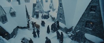 Movie still from “Harry Potter and the Prisoner of Azkaban” (2004), directed by Alfonso Cuarón – A group of people standing in the middle of a snow covered street; Extreme Wide shot, High angle