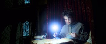 Movie still from “Harry Potter and the Prisoner of Azkaban” (2004), directed by Alfonso Cuarón – A boy is reading a book at a desk; Medium shot, High angle