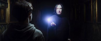 Movie still from “Harry Potter and the Prisoner of Azkaban” (2004), directed by Alfonso Cuarón – A man holding a light in his hand while standing next to another man; Medium shot, Over the shoulder angle