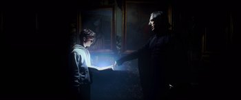 Movie still from “Harry Potter and the Prisoner of Azkaban” (2004), directed by Alfonso Cuarón – A man and a boy are holding hands in the dark; Medium shot, Low angle