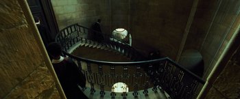 Movie still from “Harry Potter and the Prisoner of Azkaban” (2004), directed by Alfonso Cuarón – A man walking down a spiral staircase in a building; Extreme Wide shot, High angle
