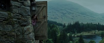 Movie still from “Harry Potter and the Prisoner of Azkaban” (2004), directed by Alfonso Cuarón – A woman leaning up against a door of a house; Wide shot, Low angle
