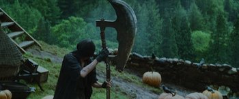 Movie still from “Harry Potter and the Prisoner of Azkaban” (2004), directed by Alfonso Cuarón – A man holding a giant axe in the middle of a forest; Medium shot, Low angle