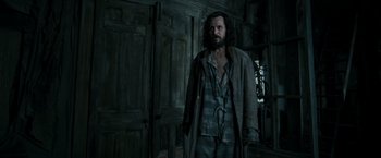 Movie still from “Harry Potter and the Prisoner of Azkaban” (2004), directed by Alfonso Cuarón – A man standing next to a door in a room; Medium shot, Low angle