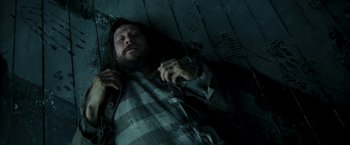 Movie still from “Harry Potter and the Prisoner of Azkaban” (2004), directed by Alfonso Cuarón – A man laying on the ground in a dark room; Medium shot, Overhead angle