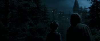 Movie still from “Harry Potter and the Prisoner of Azkaban” (2004), directed by Alfonso Cuarón – Two people standing in front of a castle at night; Extreme Wide shot, Low angle