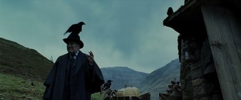 Movie still from “Harry Potter and the Prisoner of Azkaban” (2004), directed by Alfonso Cuarón – A man wearing a black hat and a long coat; Medium shot, Low angle