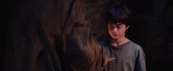 Movie still from “Harry Potter and the Sorcerer's Stone” (2001), directed by Chris Columbus – A young boy wearing glasses is looking at an older man; Medium shot, High angle