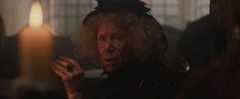 Movie still from “Harry Potter and the Sorcerer's Stone” (2001), directed by Chris Columbus – An older woman with a hat and glasses on; Close Up shot, Over the shoulder angle
