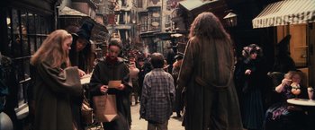 Movie still from “Harry Potter and the Sorcerer's Stone” (2001), directed by Chris Columbus – A group of people walking down a street; Wide shot, Over the shoulder angle