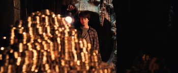 Movie still from “Harry Potter and the Sorcerer's Stone” (2001), directed by Chris Columbus – A boy is standing in front of a pile of gold coins; Medium shot, Over the shoulder angle