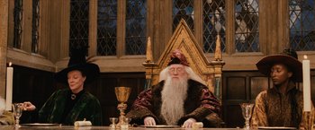 Movie still from “Harry Potter and the Sorcerer's Stone” (2001), directed by Chris Columbus – An old man sitting at a table in front of a glass goblet; Medium shot, Over the shoulder angle