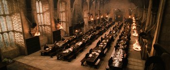 Movie still from “Harry Potter and the Sorcerer's Stone” (2001), directed by Chris Columbus – People are sitting at tables in an auditorium; Extreme Wide shot, High angle