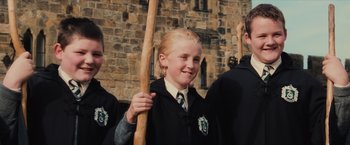 Movie still from “Harry Potter and the Sorcerer's Stone” (2001), directed by Chris Columbus – A boy in a uniform holding a wooden stick; Medium shot, Low angle