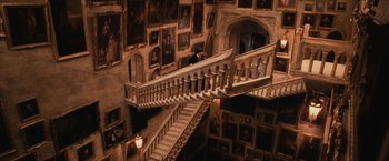 Movie still from “Harry Potter and the Sorcerer's Stone” (2001), directed by Chris Columbus – A staircase in a room with many pictures on the walls; Extreme Wide shot, High angle