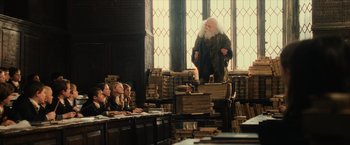 Movie still from “Harry Potter and the Sorcerer's Stone” (2001), directed by Chris Columbus – An old man is standing in front of a bunch of books; Wide shot, Low angle