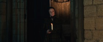 Movie still from “Harry Potter and the Sorcerer's Stone” (2001), directed by Chris Columbus – A woman holding a candle in a dark room; Medium shot, Low angle