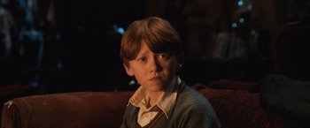 Movie still from “Harry Potter and the Sorcerer's Stone” (2001), directed by Chris Columbus – A young boy sitting on a couch in front of a window; Close Up shot, High angle