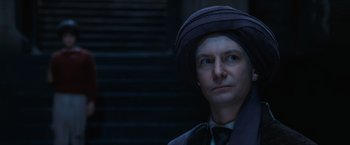 Movie still from “Harry Potter and the Sorcerer's Stone” (2001), directed by Chris Columbus – A man in a hat and a suit looking to his left; Close Up shot, Low angle