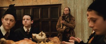 Movie still from “Harry Potter and the Sorcerer's Stone” (2001), directed by Chris Columbus – A man holding a dog in his arms; Medium shot, Over the shoulder angle