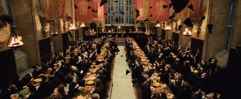 Movie still from “Harry Potter and the Sorcerer's Stone” (2001), directed by Chris Columbus – A large group of people sitting at a long table; Extreme Wide shot, High angle