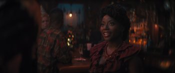 Movie still from “Haunted Mansion” (2023), directed by Justin Simien – A woman sitting at a table with a glass in front of her; Close Up shot, Over the shoulder angle